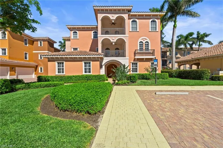 View of front facade featuring a balcony, a front yard, and stucco siding
