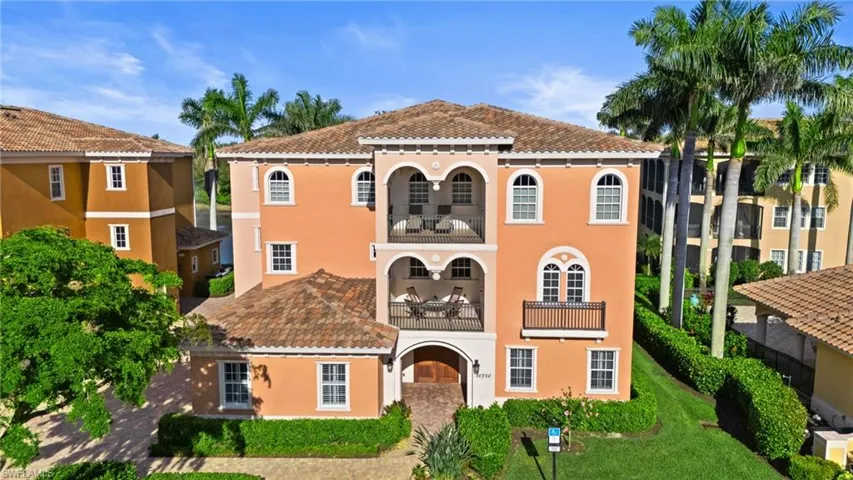 Mediterranean / spanish house featuring a tile roof, a balcony, stucco siding, and a front lawn
