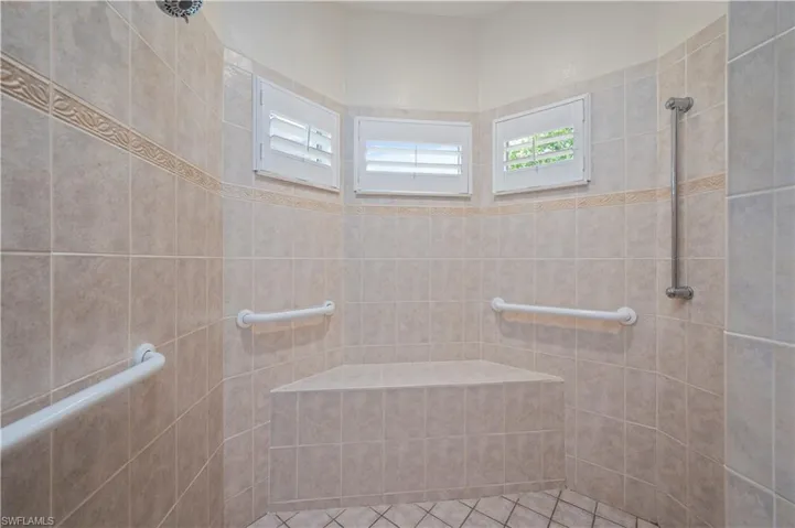 Bathroom with tiled shower and tile patterned flooring