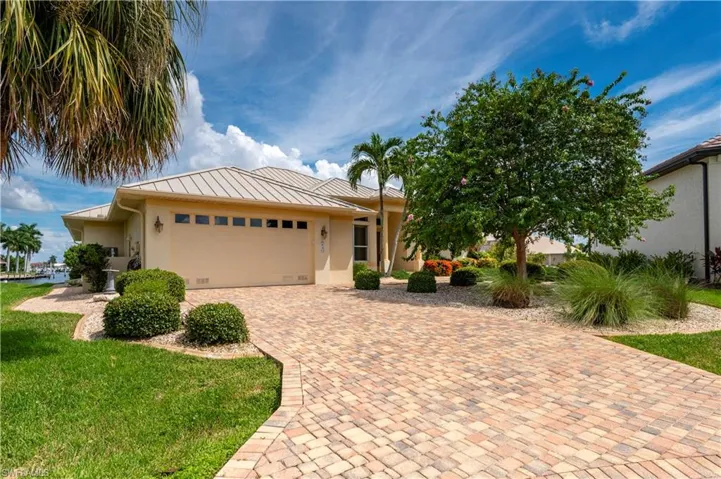 View of front of home with a garage and a front lawn