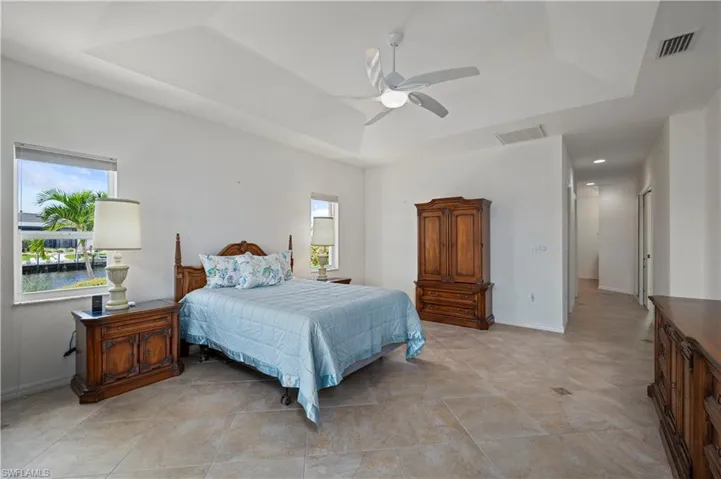 Bedroom featuring ceiling fan and a tray ceiling