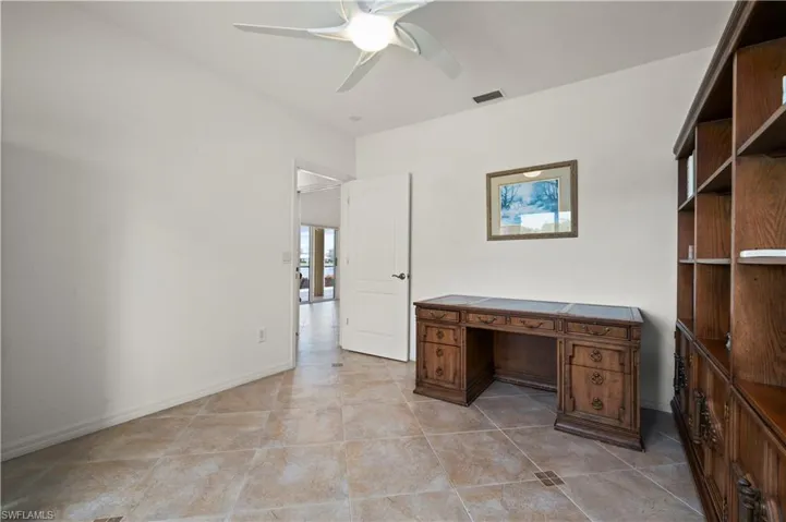 Unfurnished office with ceiling fan and light tile patterned floors