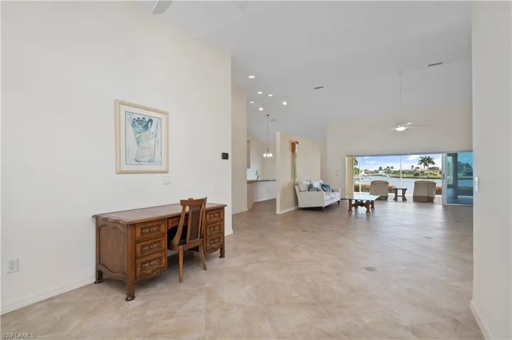 Hallway featuring a towering ceiling and light tile patterned flooring