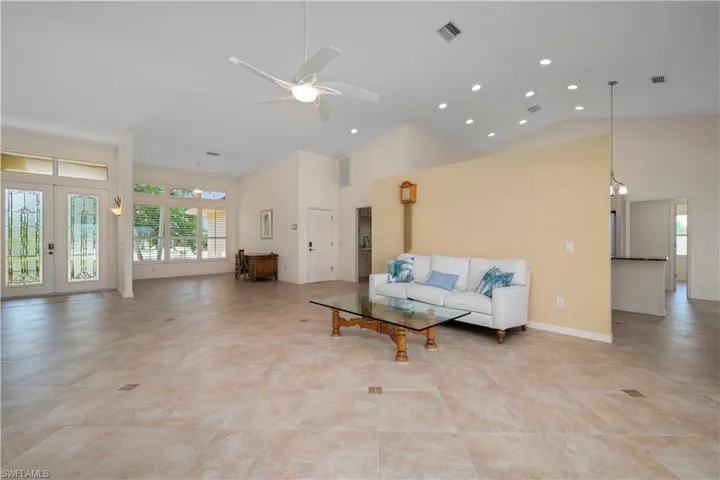 Unfurnished living room with high vaulted ceiling and ceiling fan