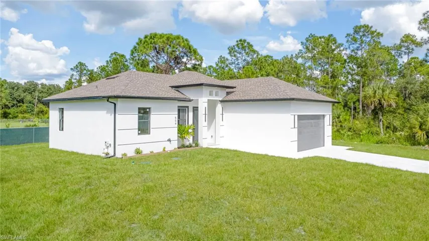 Contemporary-style exterior with a clean white stucco finish, dark asphalt shingle roof, and an attached garage with a dark gray door