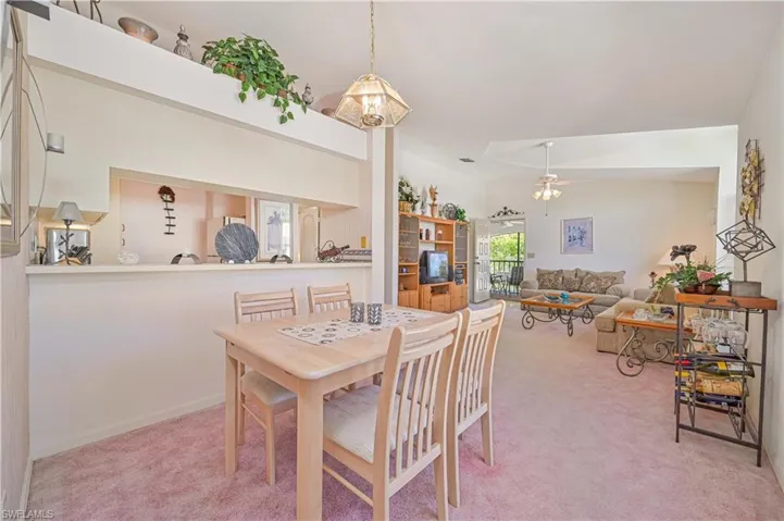 Dining space with light carpet and ceiling fan