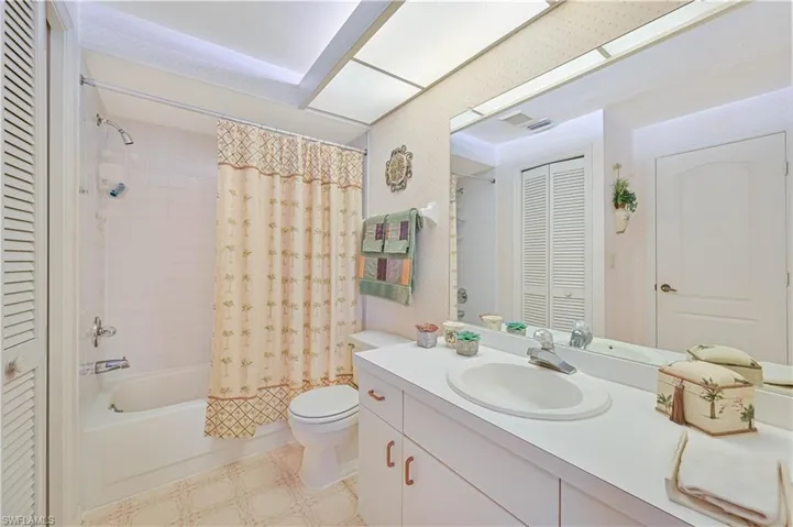 Full bathroom with a closet, toilet, vanity, shower / tub combo, and visible vents