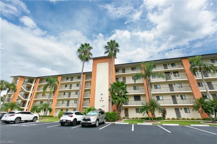 View of apartment building / complex featuring uncovered parking