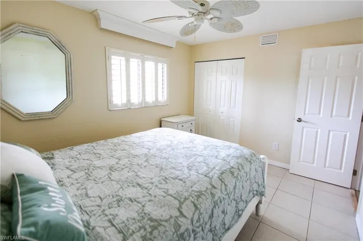 Bedroom with light tile patterned floors, a ceiling fan, and a closet