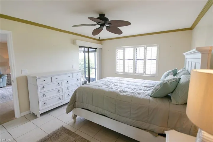 Bedroom featuring access to outside, ornamental molding, light tile patterned floors, and ceiling fan