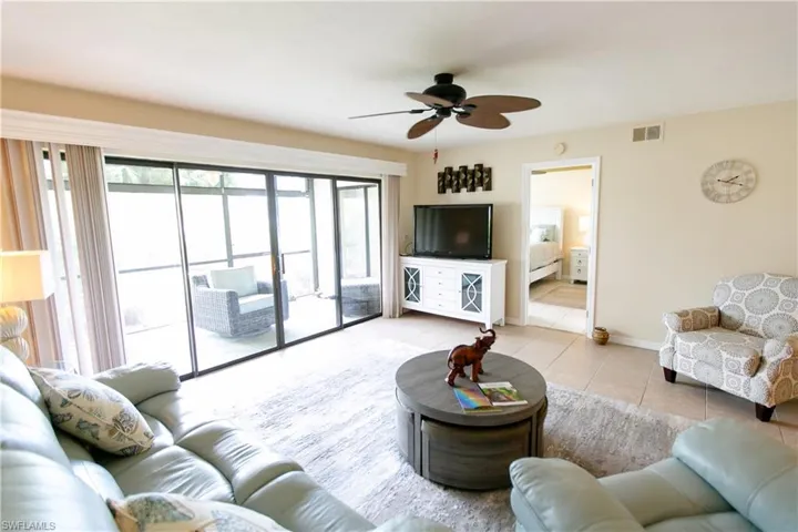 Living area featuring light tile patterned flooring and a ceiling fan