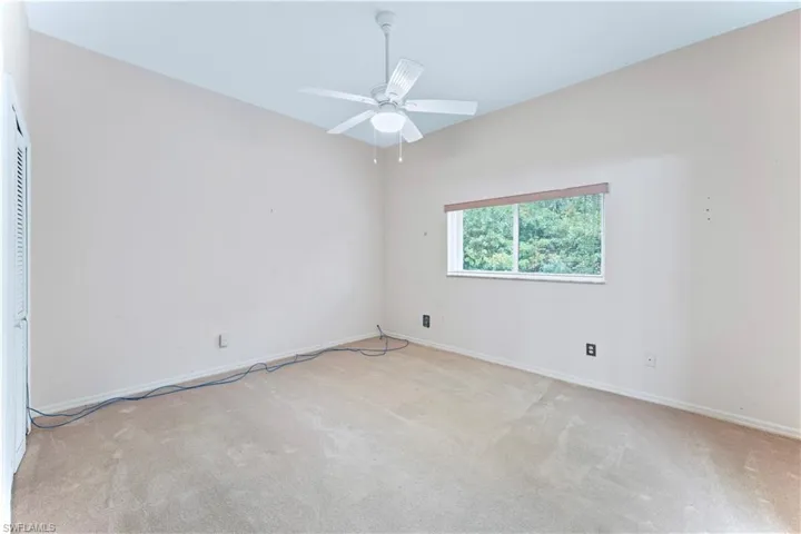 Carpeted spare room featuring ceiling fan