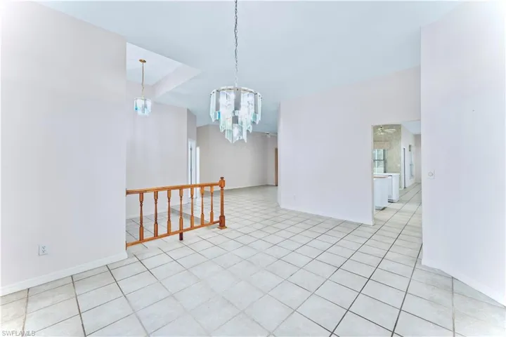 Unfurnished room featuring a notable chandelier