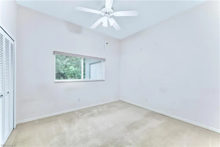 Carpeted empty room with ceiling fan