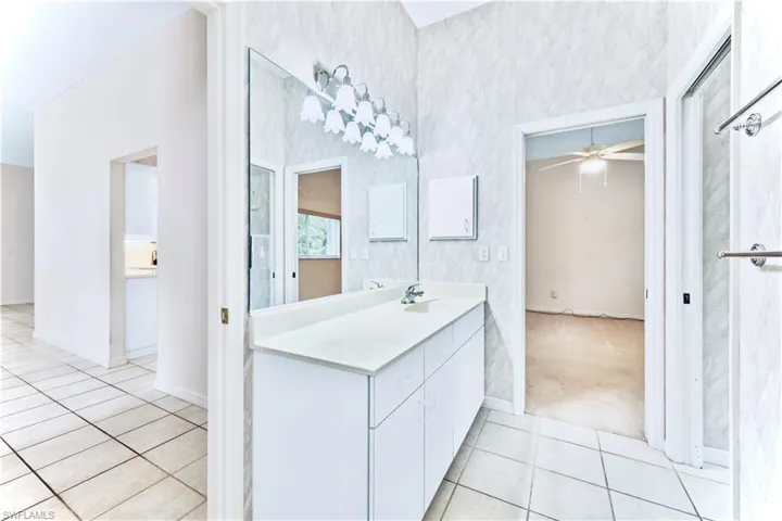 Bathroom featuring ceiling fan, tile patterned floors, and vanity