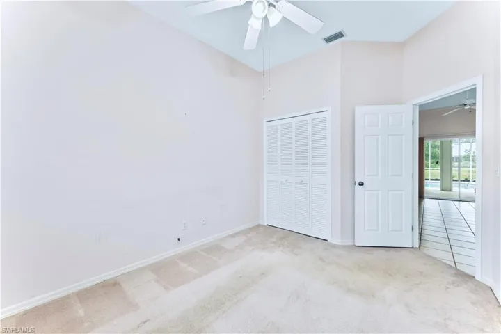 Unfurnished bedroom with ceiling fan, light carpet, and a closet