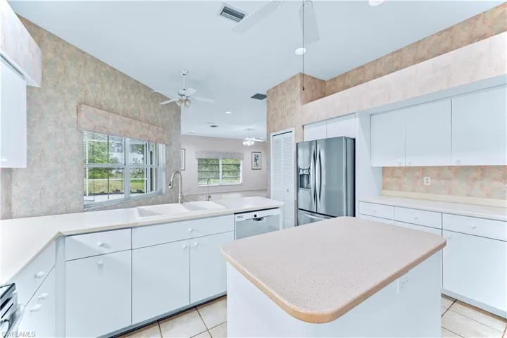 Kitchen featuring white cabinetry, stainless steel appliances, and a kitchen island