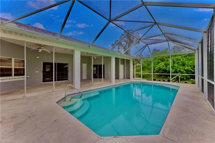 View of swimming pool featuring a patio, a lanai, and ceiling fan