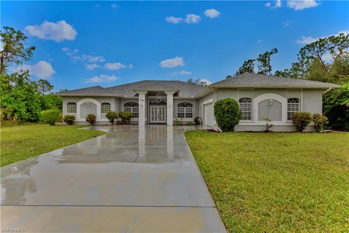 View of front of property featuring a garage and a front yard