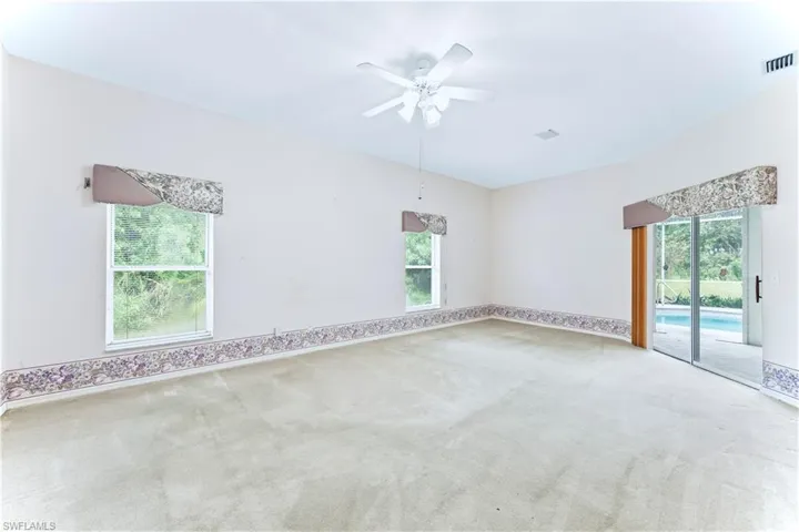 Carpeted spare room with ceiling fan