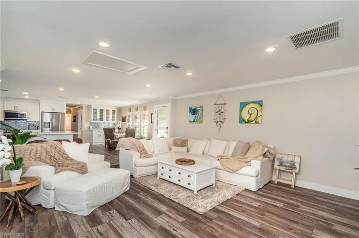 Living room featuring ornamental molding, dark wood finished floors, recessed lighting, and attic access