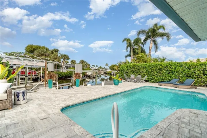 Swimming pool with a patio and a water view