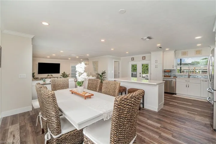 Dining area with recessed lighting, crown molding, dark wood-style flooring, and french doors