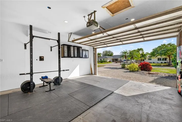 Garage featuring a garage door opener, a residential view, and recessed lighting