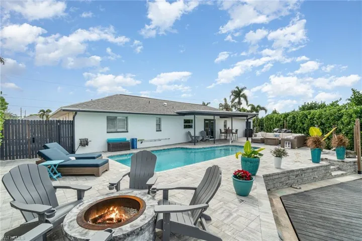 View of swimming pool with a patio and an outdoor living space with a fire pit