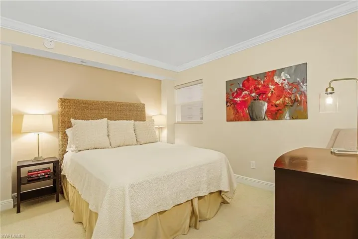 Carpeted bedroom featuring crown molding