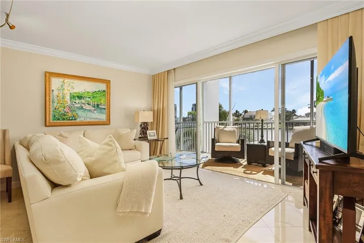 Living room featuring light tile patterned flooring and crown molding