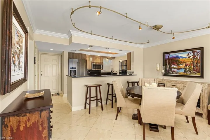 Tiled dining room with sink and ornamental molding