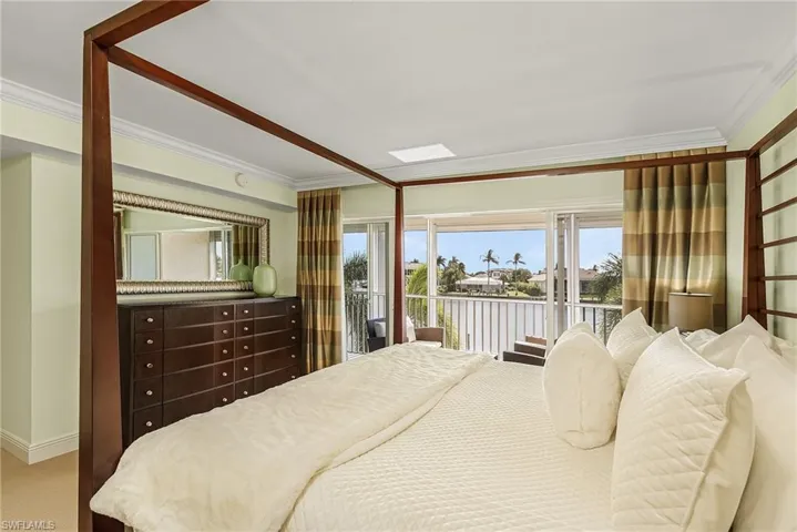 Carpeted bedroom featuring ornamental molding, access to outside, and a water view