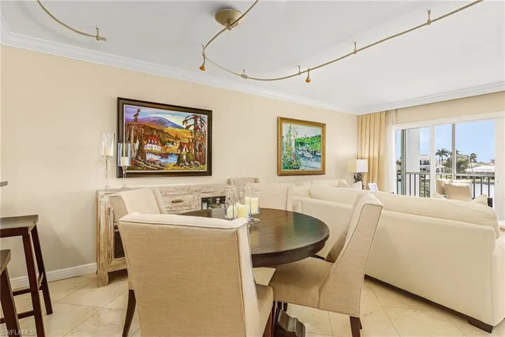Dining area with light tile patterned flooring and crown molding