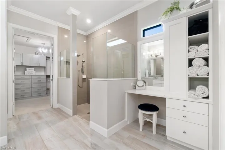 Bathroom featuring a shower, vanity, and crown molding