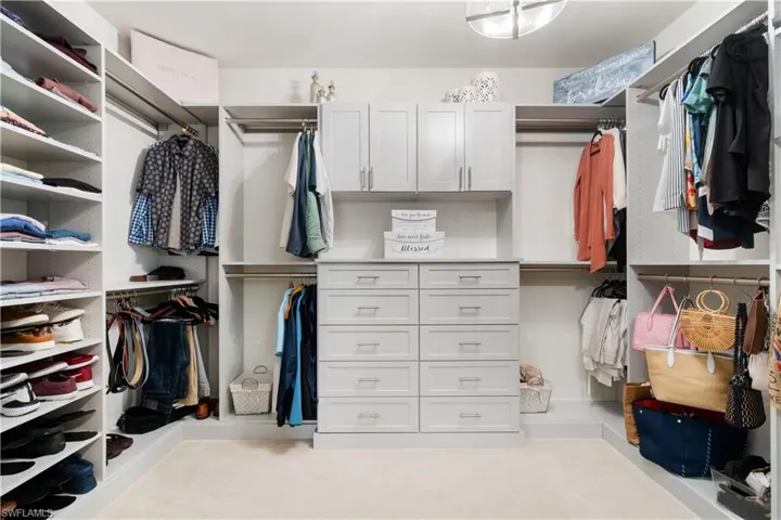 Spacious closet with light colored carpet