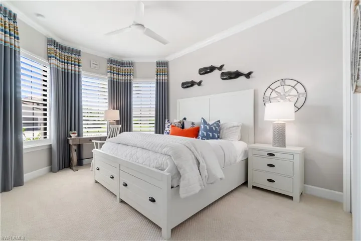 Carpeted bedroom featuring ornamental molding and ceiling fan