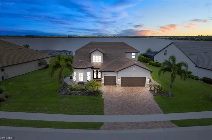 View of front facade with a garage and a yard