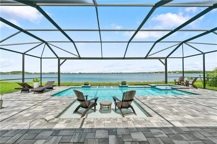 View of pool with a patio, an in ground hot tub, a water view, and a lanai