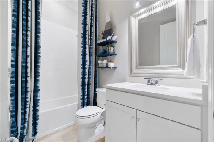 Full bathroom featuring vanity, shower / bath combo, and toilet