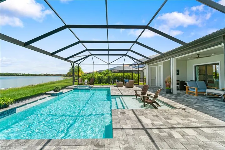 View of swimming pool with a patio, ceiling fan, and a lanai