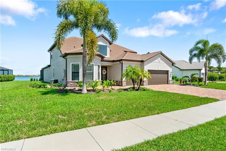 View of front of house featuring a garage, a water view, and a front yard