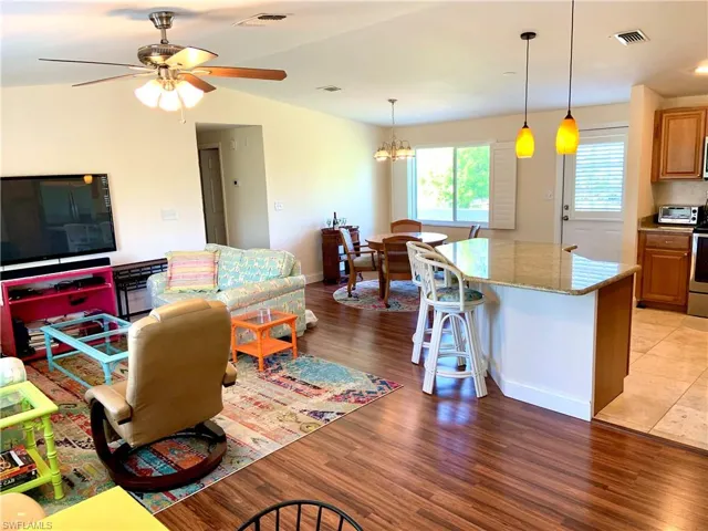 Great room with a large island and dining with chandelier