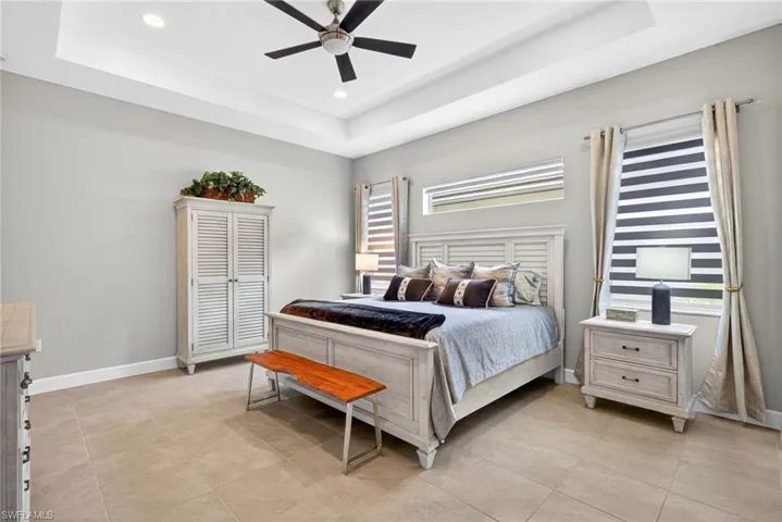 Tray ceiling present in this generously sized 16'6" x 14'8" primary bedroom that holds a king sized bed, 2 night stands, a triple dresser, an armoire and room for a chair, too! Motorized blind on window above bed!