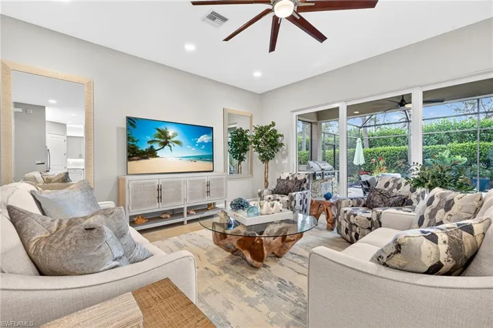 This great room features rear and side walls of zero corner sliding doors which provide lots of FL sunshine and view of pool!
