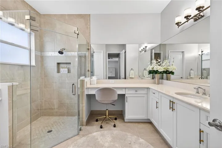 Seamless shower door, floor to ceiling tile in shower, vanity area in primary bath...