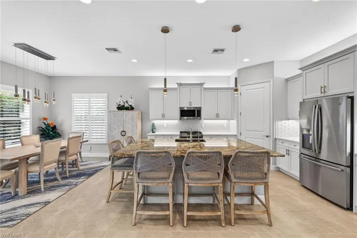 Note the coordinating lighting on the kitchen and dining area? French door fridge, upgraded dishwasher, Blanco sink and Moen faucet present, too!