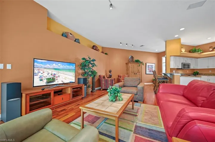 Living room with rail lighting and wood-type flooring
