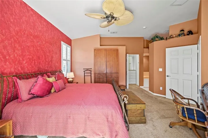 Bedroom with ceiling fan and light carpet