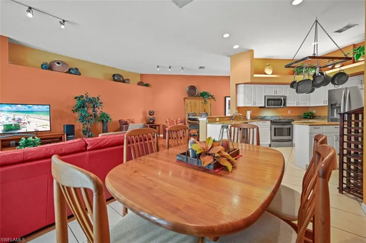 Dining space with track lighting, light tile patterned floors, and sink
